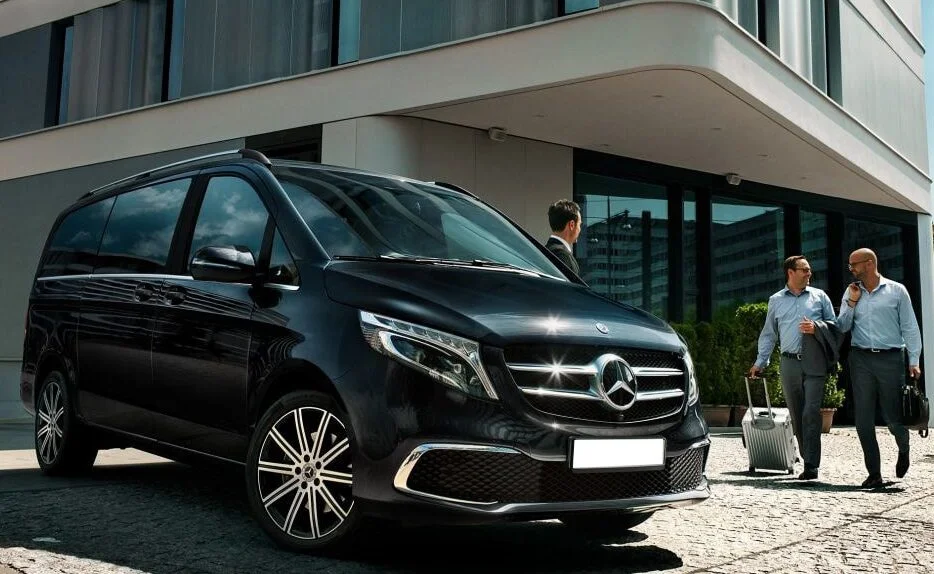 A sleek black Mercedes-Benz parked in front of a modern building.