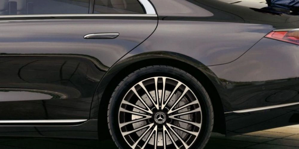 Close-up of a luxury car's rear wheel and part of the rear door.