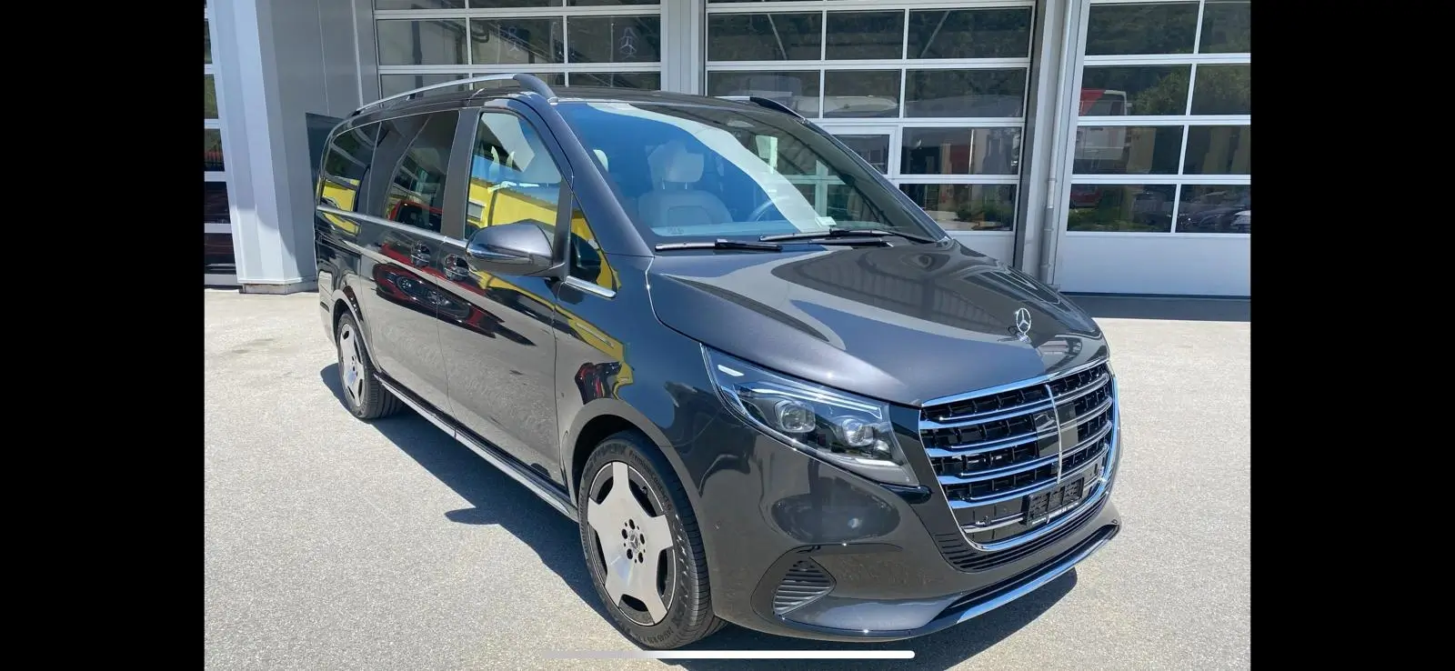 A sleek black luxury van parked outdoors.