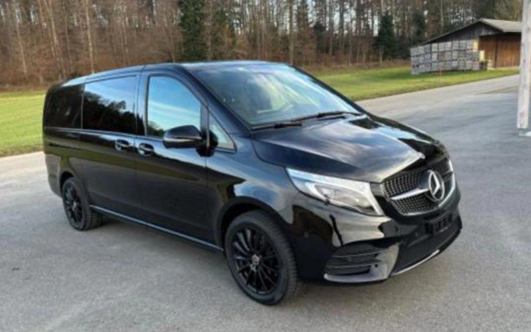 Black luxury van parked on a driveway with tinted windows.
