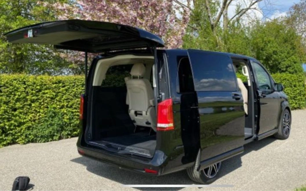 Black van with open rear door showing empty cargo space.