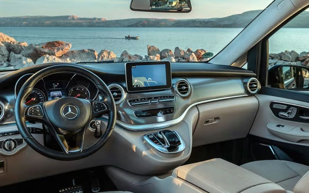 Luxurious Mercedes-Benz interior with a scenic ocean view through the windshield.